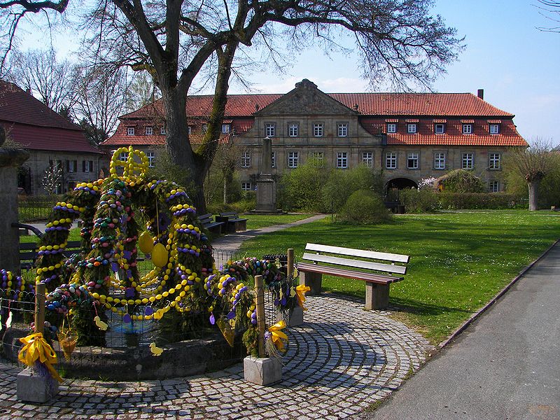 The grange of the monastery of Langheim. Plants at the forefront of the image are decorated with gold and purple ribbons.