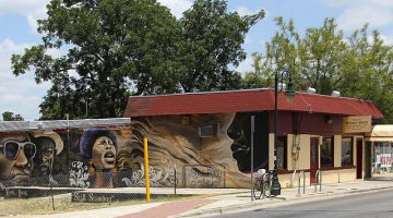 Photograph of the front facade of the Victory Grill showing a mural of African American figures painted along the side of the building