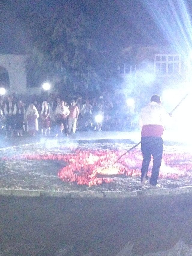 1The Nestinarka or coal-walker (in white head scarf) swirls a small urn of burning embers in the air at the beginning of the procession with holy icons into the woods. (Village of Bulgari, in Southeastern Bulgaria, June 2015).