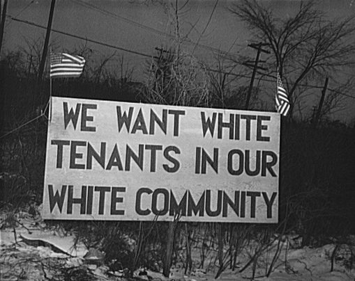 Black and white image of a white sign that says in black letters "We want white tenants in our white community" from 1942
