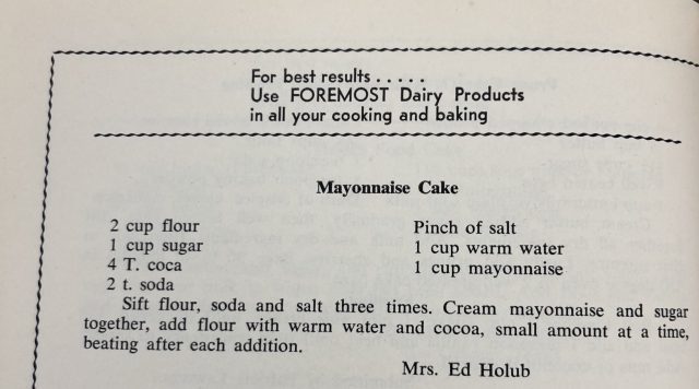 A close-up photograph of a recipe book showing the ingredients and instructions for making Mayonnaise Cake