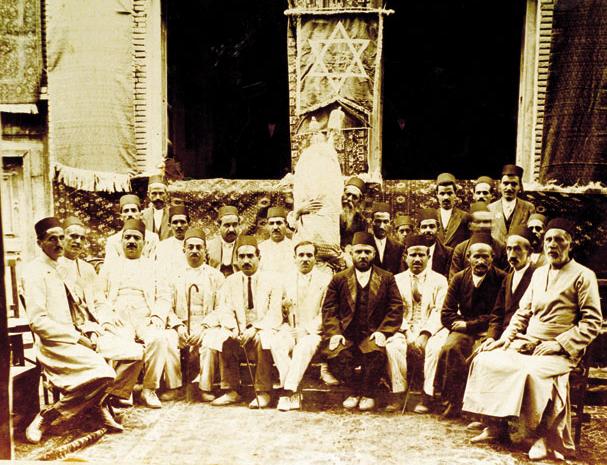 A group of Iranian jews seated in a double semi-circle in Hamedan, Iran in 1917