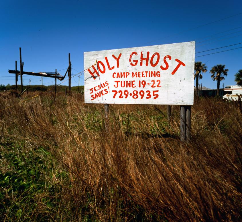 An image of a white sign with red letters advertising a Holy Ghost Camp Meeting