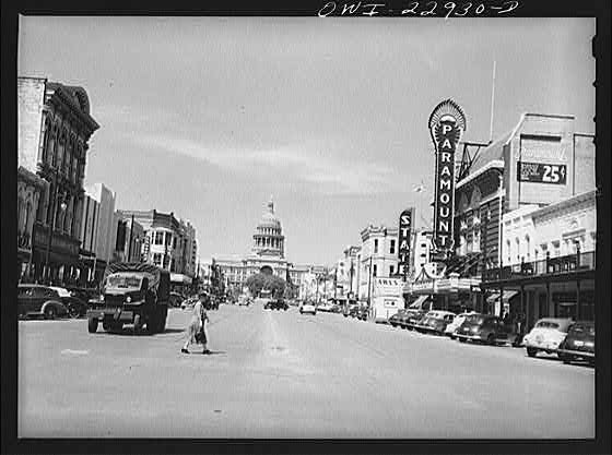 Black and white photograph of Congress Avenue in downtown Austin, Texas with a view of the State Capital Building in the background