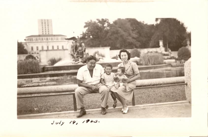Image of an Asian family from July 19, 1943 sitting on the edge of a fountain on the campus of the University of Texas at Austin