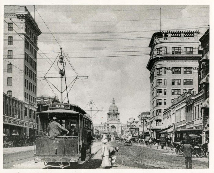 Black and white image of a trolley car moving down Congress Avenue towards the Texas State Capital Building