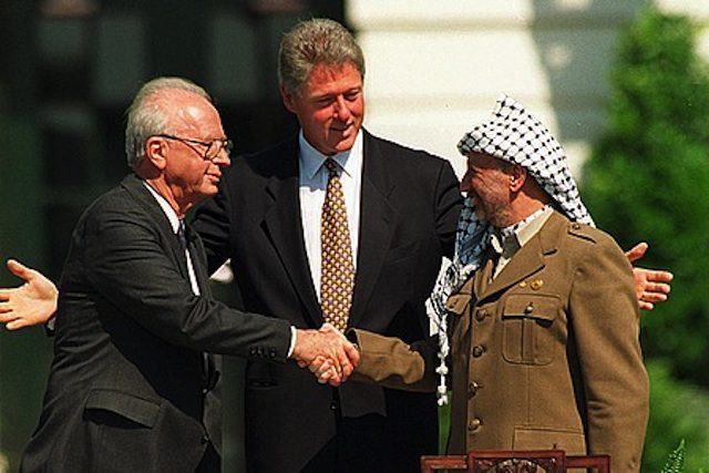 Israeli Prime Minister Yitzhak Rabin, left, shaking hands with PLO Chairman Yasser Arafat, with U.S. President Bill Clinton in the center at the Oslo Accords signing ceremony, Sept. 13, 1993. (Vince Musi / The White House)