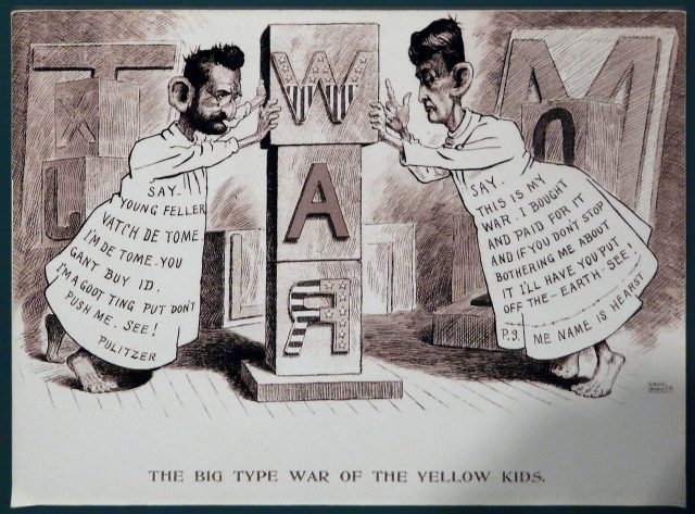 "Yellow journalism" cartoon about Spanish–American War of 1898, Independence Seaport Museum. The newspaper publishers Joseph Pulitzer and William Randolph Hearst are both attired as the Yellow Kid comics character of the time, and are competitively claiming ownership of the war