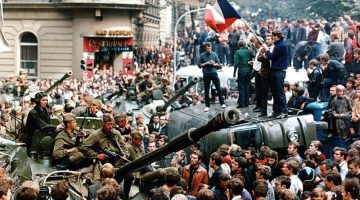 People standing on cars and military vehicles in crowded streets during the so-called Prague Spring reform