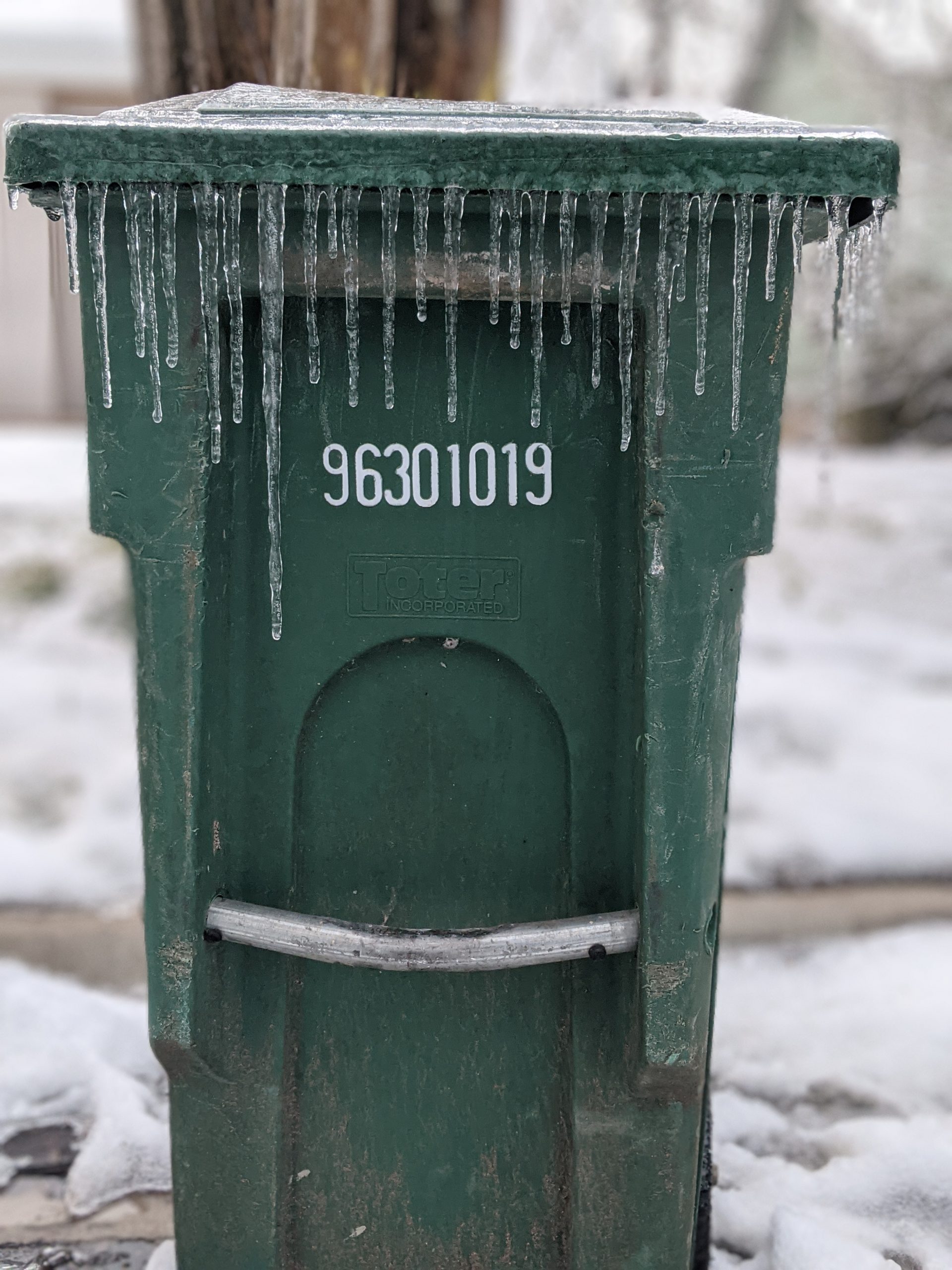 Garbage can with icicles hanging from the lid