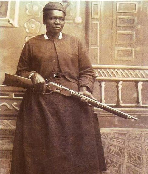 Stagecoach Mary poses for a photo holding a shotgun