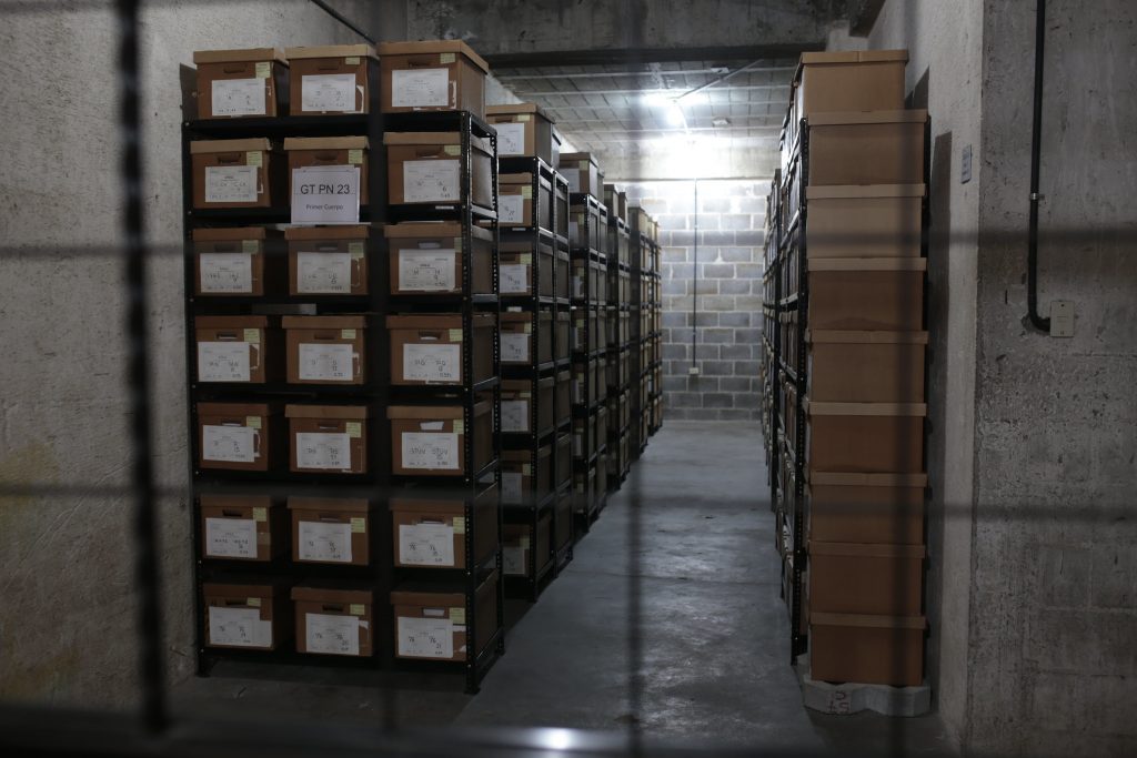 Boxes are stacked on shelves and housed in a concrete room