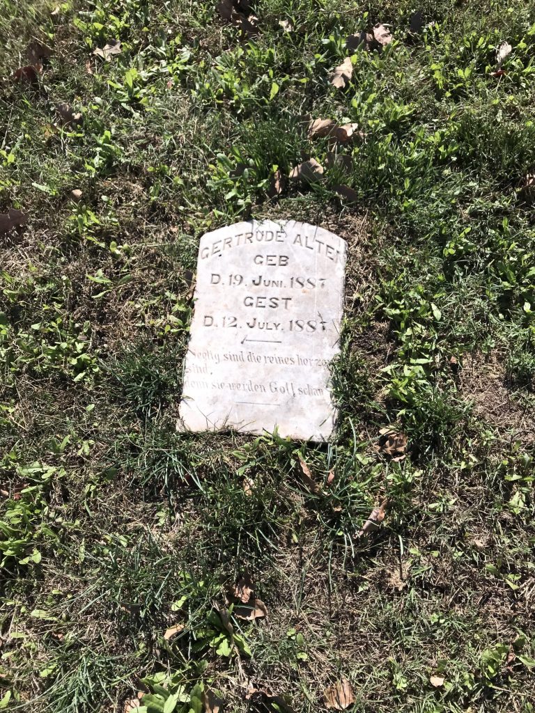 A gravestone bearing the inscription: "Gertrude Alten, GEB D. 19 Juni 1887, GEST D. 12 July 1887. Seelig sind die reines herzen sind, denn sie werden Gott [schau?]."