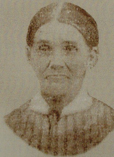 A photographic portrait of Rebecca McIntosh Hawkins Hagerty. The photograph is faded and grainy but appears to show a solemn-faced woman, not young, who has tightly-parted dark hair.