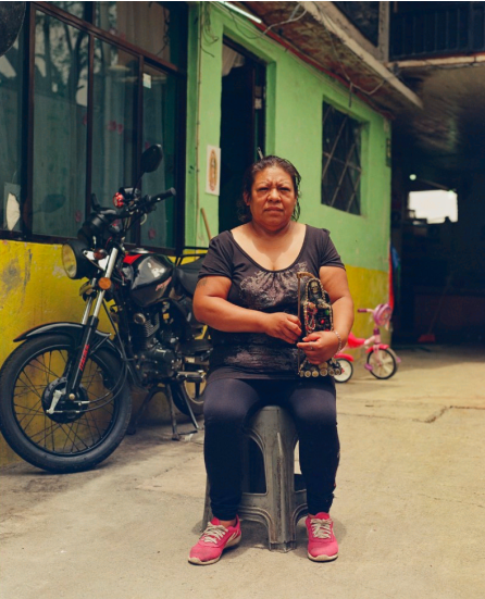 Maritza, the owner of a chicken store in Zumpango, poses with her personal statuette. A
Virgen de Guadalupe guards a door that leads to her private Santa Muerte altar.