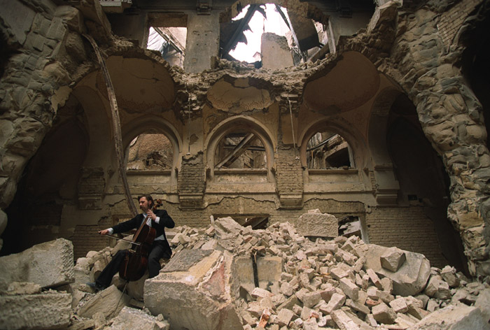 This image was taken during the war in 1992 in Sarajevo in the partially destroyed National Library. The cello player is local musician Vedran Smailović, who often came to play for free at different funerals during the siege despite the fact that funerals were often targetted by Serb forces. (Mikhail Evstafiev)