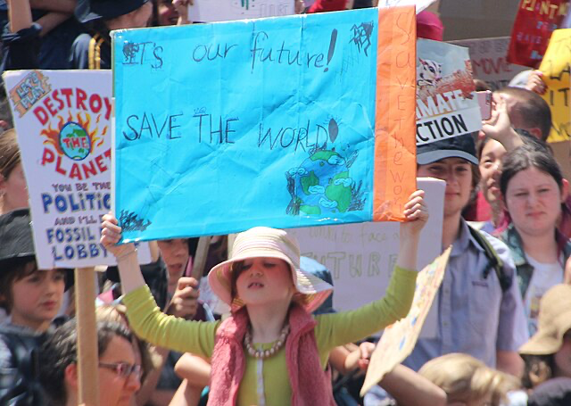 Kids holding sign that reads: It's our future! Save the world!