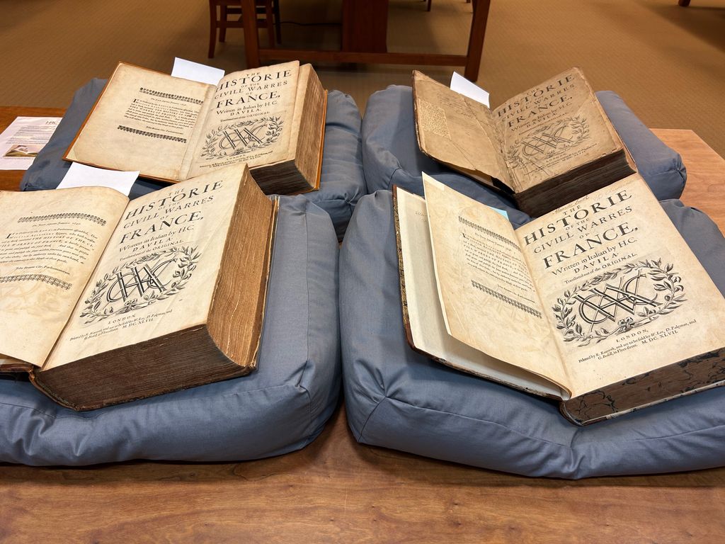 The Ransom Center's four copies of The Historie of the Civill Warres of France open on a table.