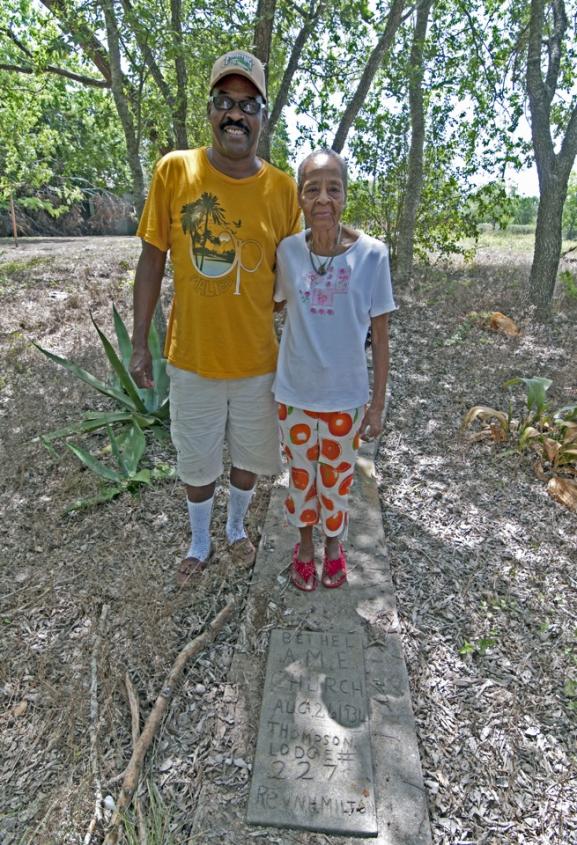 Photograph of an African American couple standing next to a marker showing where the Bethel A.M.E. church used to be